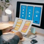 ux designer is reviewing paper prototypes of a mob nlr769m
