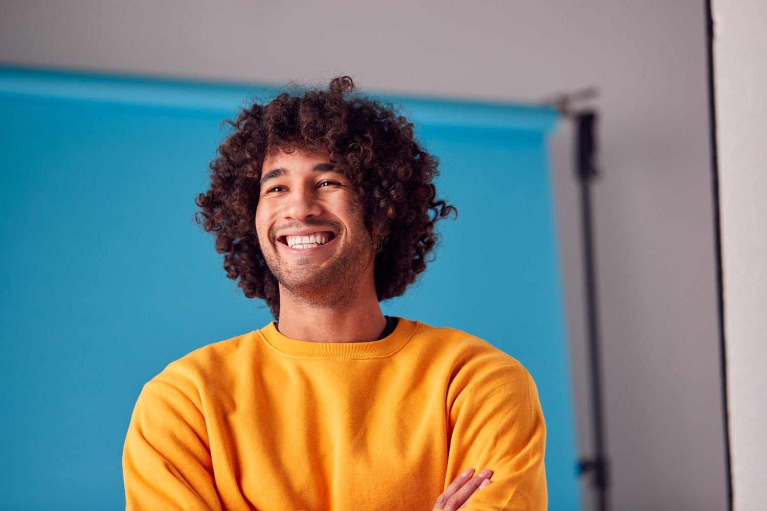 studio portrait of smiling young man against blue 2ytyfzf.jpg