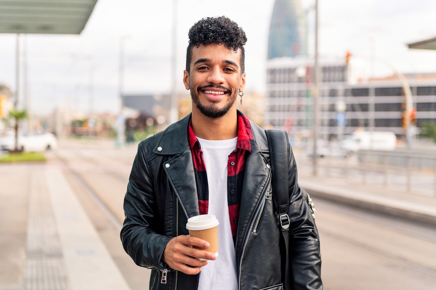 young latin guy smiles with a coffee on his hand 7amum4x.jpg